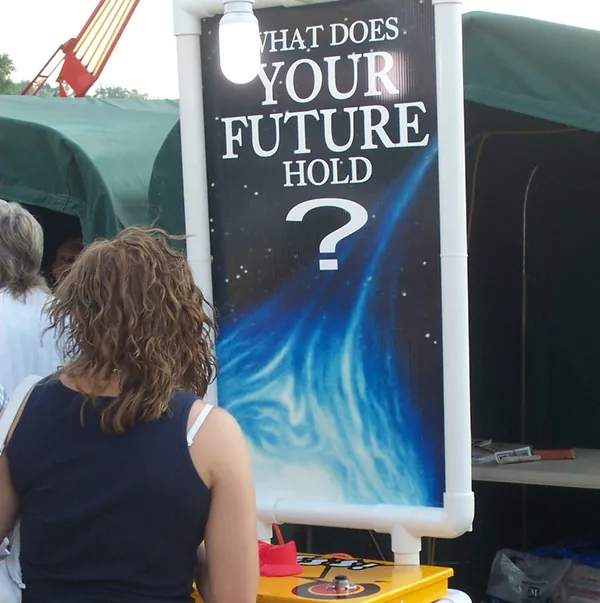 A fairgoer reading the booth’s sign, which asks “What does your future hold?”